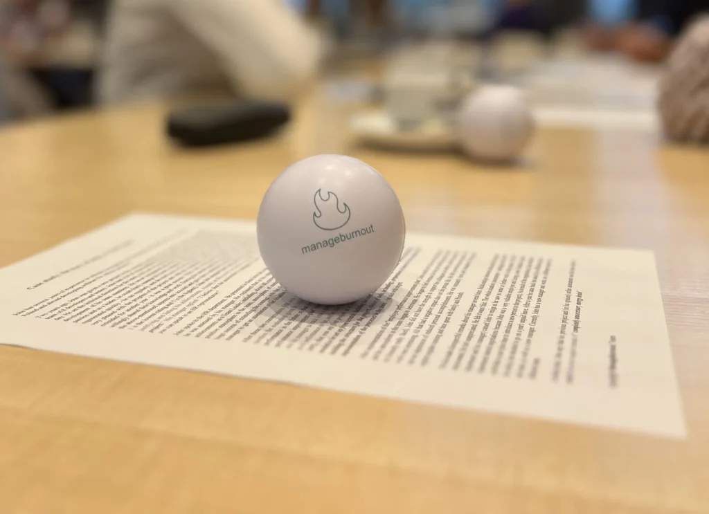 The photo shows a ball with the Manageburnout logo on a piece of paper from the Case Study during a workshop on burnout.